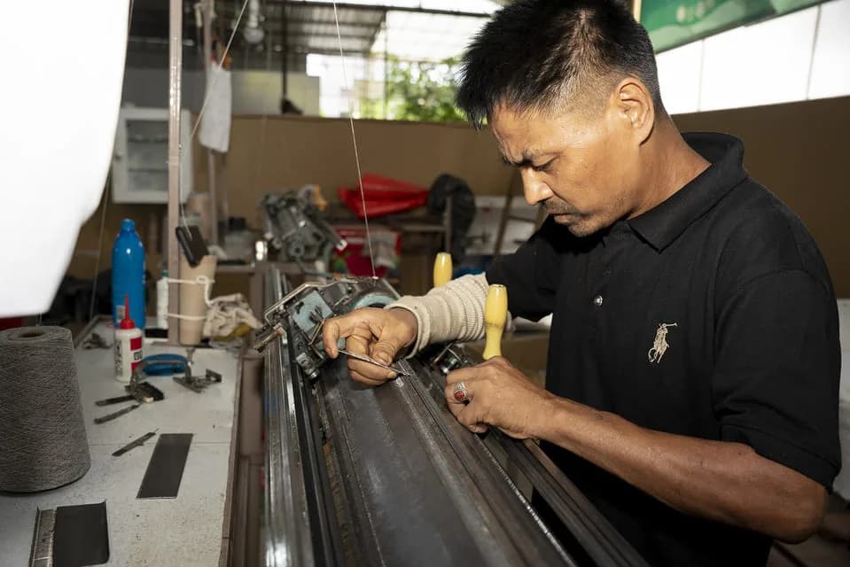 Hira Lal Tamang at his knitting machine in the Yes Helping Hand workshop, Pokhara